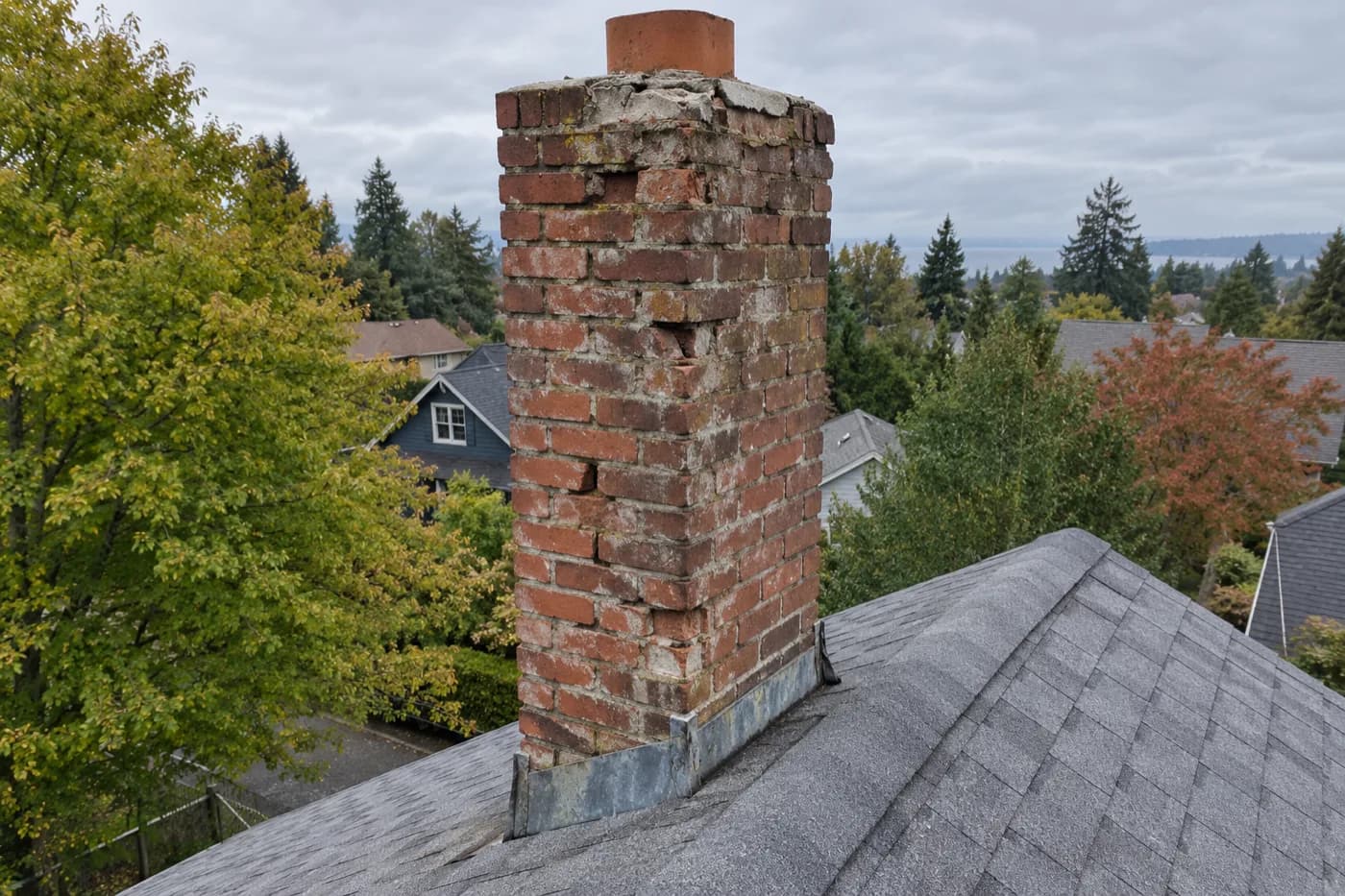 Before: Roman brick chimney in Rainier Valley with spalled faces and a broken crown, before being rebuilt from the roofline up